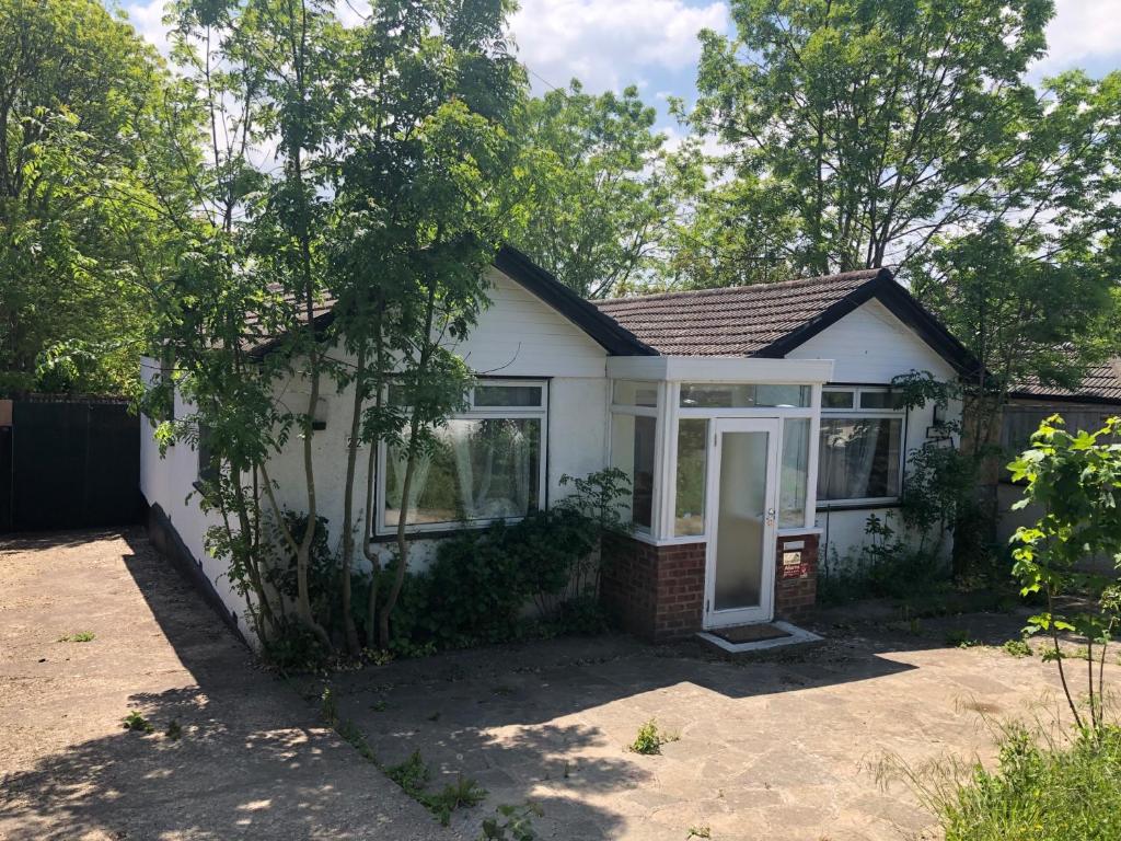 a small white house with a conservatory at 3 Bed Cottage Retreat - Private Garden & Parking in Orpington