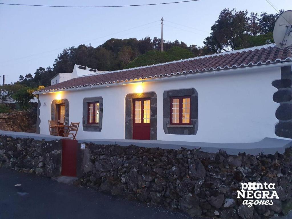 una casa bianca con un muro di pietra di Charming Country House by Ponta Negra Azores a Altares