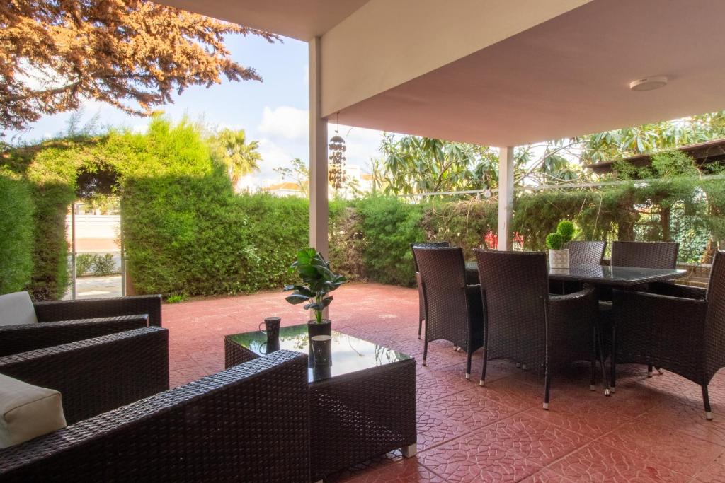 an outdoor patio with tables and chairs and a table at Large Veranda 2BR Walk to Beach in Paralimni