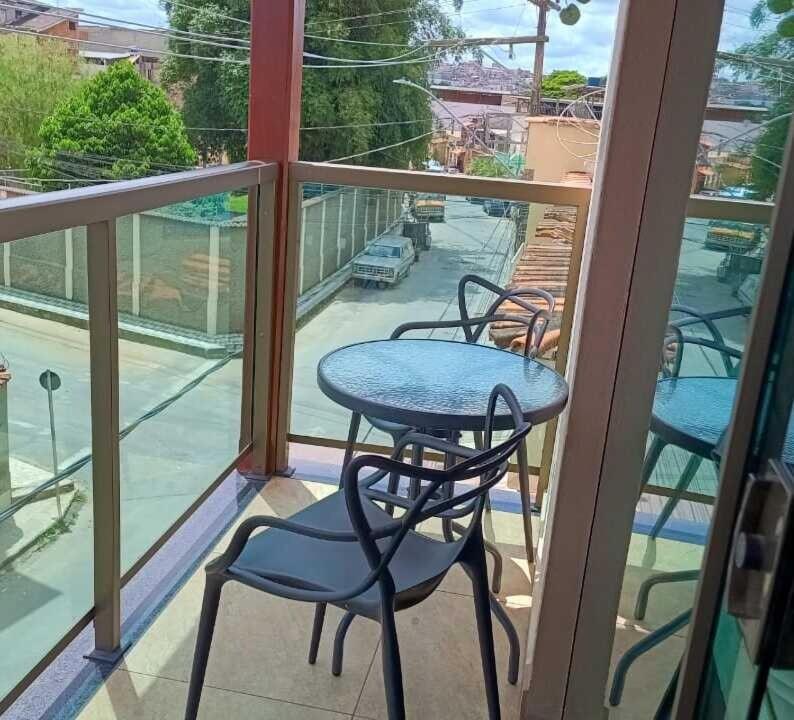 balcone con tavolo, sedie e vista sulla strada di Casa Completa com Varanda Garagem Wi fi Suíte a São João del Rei
