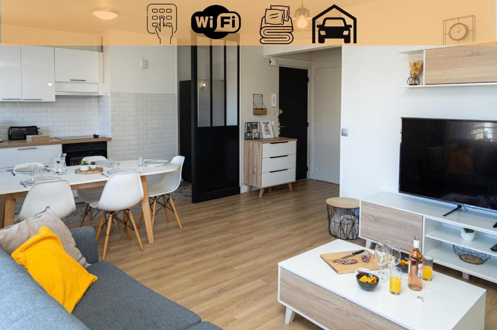 un salon et une cuisine avec un canapé et une table dans l'établissement L'escapade Paloise, Balcon, Garage privé, à Pau
