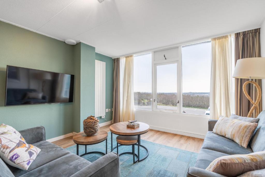 una sala de estar con un sofá y una mesa en Appartementencomplex Juliana 124, en De Koog