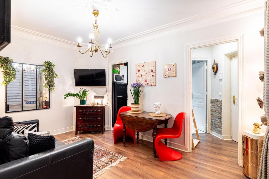 un salon avec une table et des chaises rouges dans l'établissement GuestReady - Comfy stay near Place de la Nation, à Paris