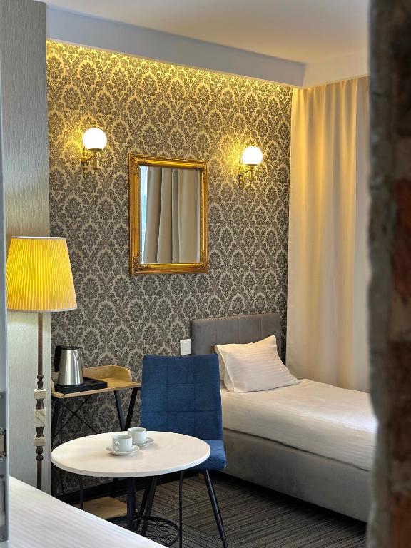 a hotel room with a bed and a table and a mirror at Pensjonat Gogol.s in Wrocław