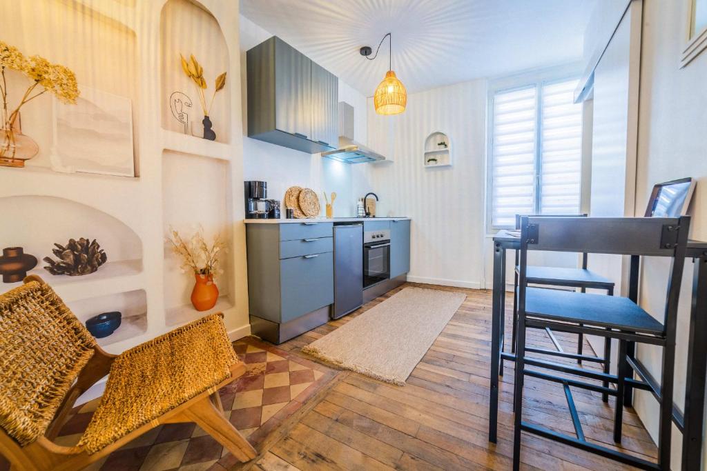 une cuisine avec des armoires bleues et une table et des chaises dans l'établissement Dolce Dali - 1 Piece, à Brive-la-Gaillarde