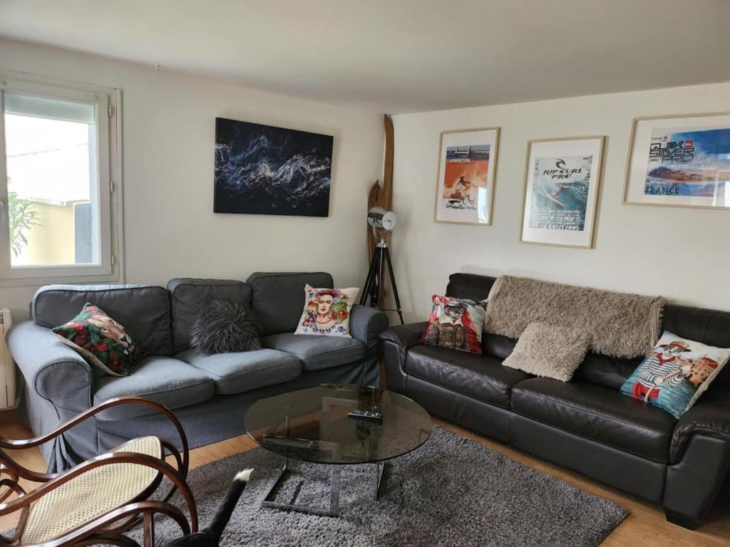 un salon avec un canapé noir et une table dans l'établissement Repère des etoiles, à Saint-Beauzire