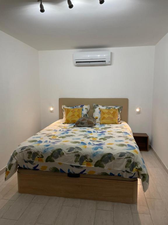 - une chambre avec un lit doté d'une couette et d'oreillers dans l'établissement Maisonnette tout confort, à Fabrègues