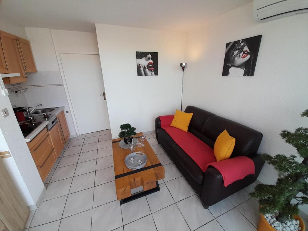 un salon avec un canapé et une table dans l'établissement Appartement Village naturiste Leather, au Cap d'Agde