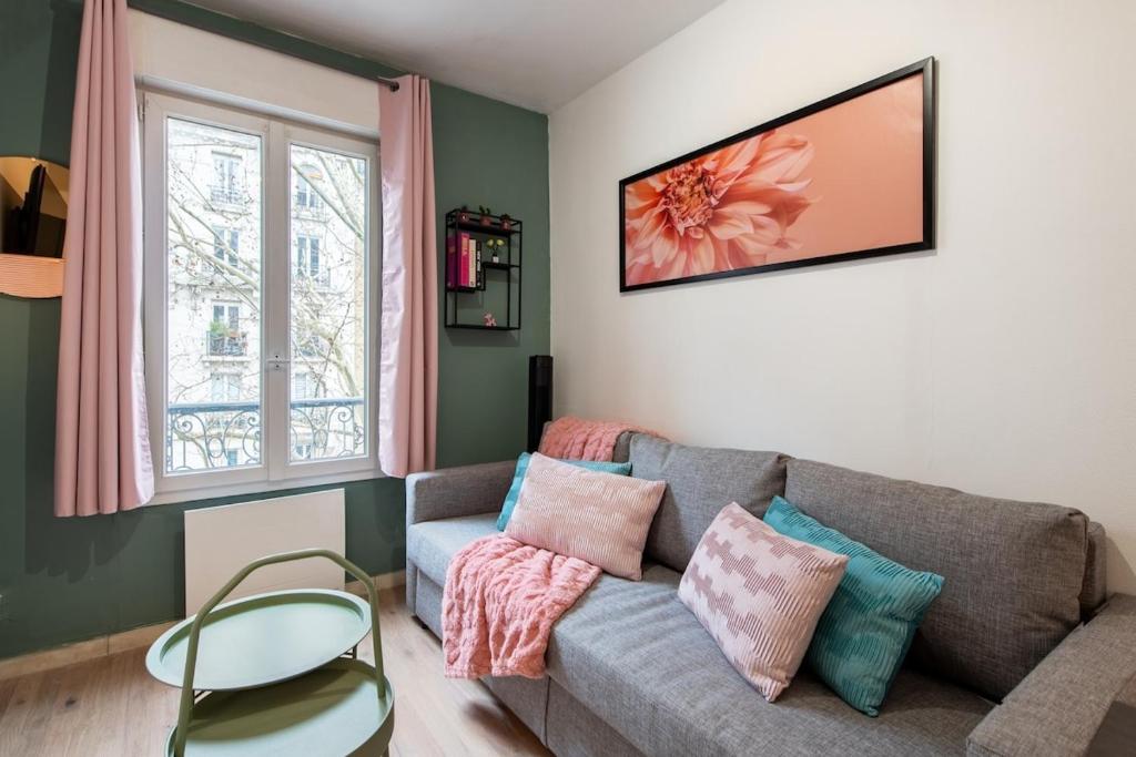un salon avec un canapé et une fenêtre dans l'établissement Stylish & Elegant I Metro is only 1minute away I Near Montmartre, à Paris