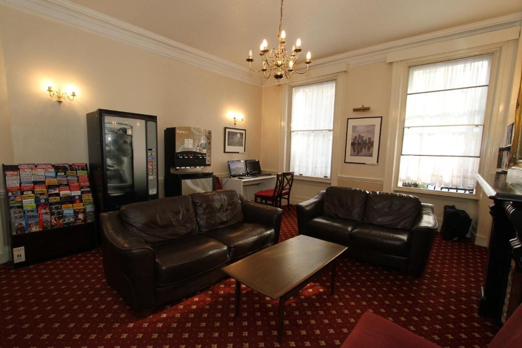 a living room with a couch and a table at Ridgemount Hotel in London