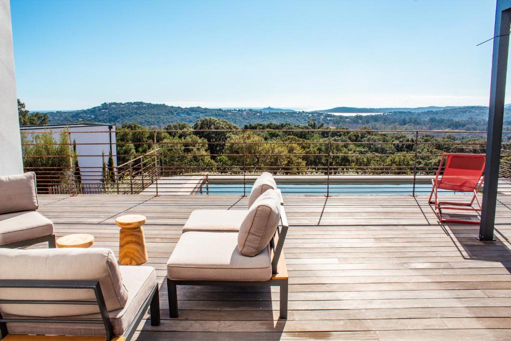 une terrasse avec deux canapés et des chaises ainsi qu'une piscine dans l'établissement Villa Balancinu, à Sainte-Lucie de Porto-Vecchio
