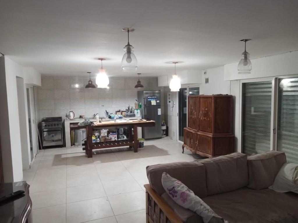 Una sala de estar con un sofá y una cocina. en Casa Madre City Bell, en City Bell