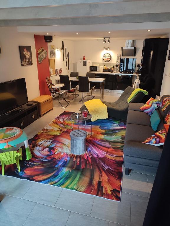 - un salon avec un tapis coloré au sol dans l'établissement Le logis d'Hélène, à Selongey