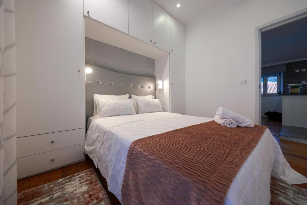 a bedroom with a large bed with a large headboard at Guest House Abegorias Nazaré in Nazaré