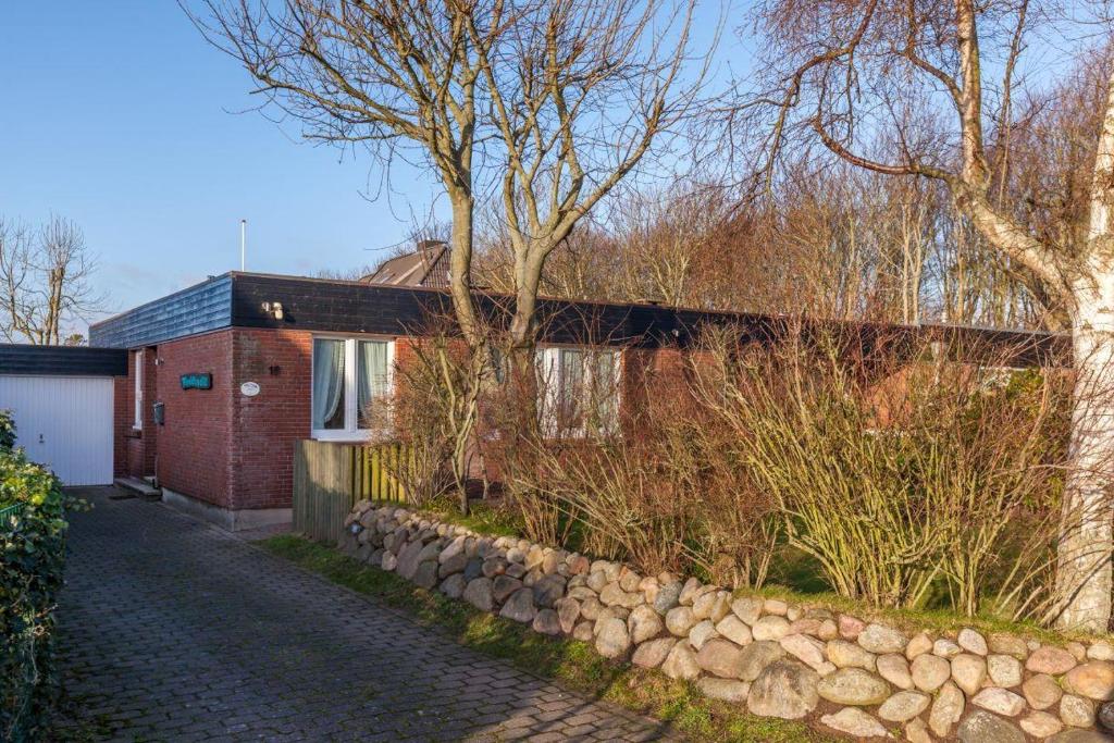 una casa de ladrillo rojo con una pared de piedra en Finlandia Bungalow, en Süderende