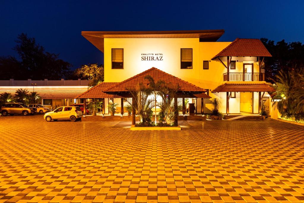 un edificio amarillo con un aparcamiento a cuadros en Kwality's Motel Shiraz, en Bhopal