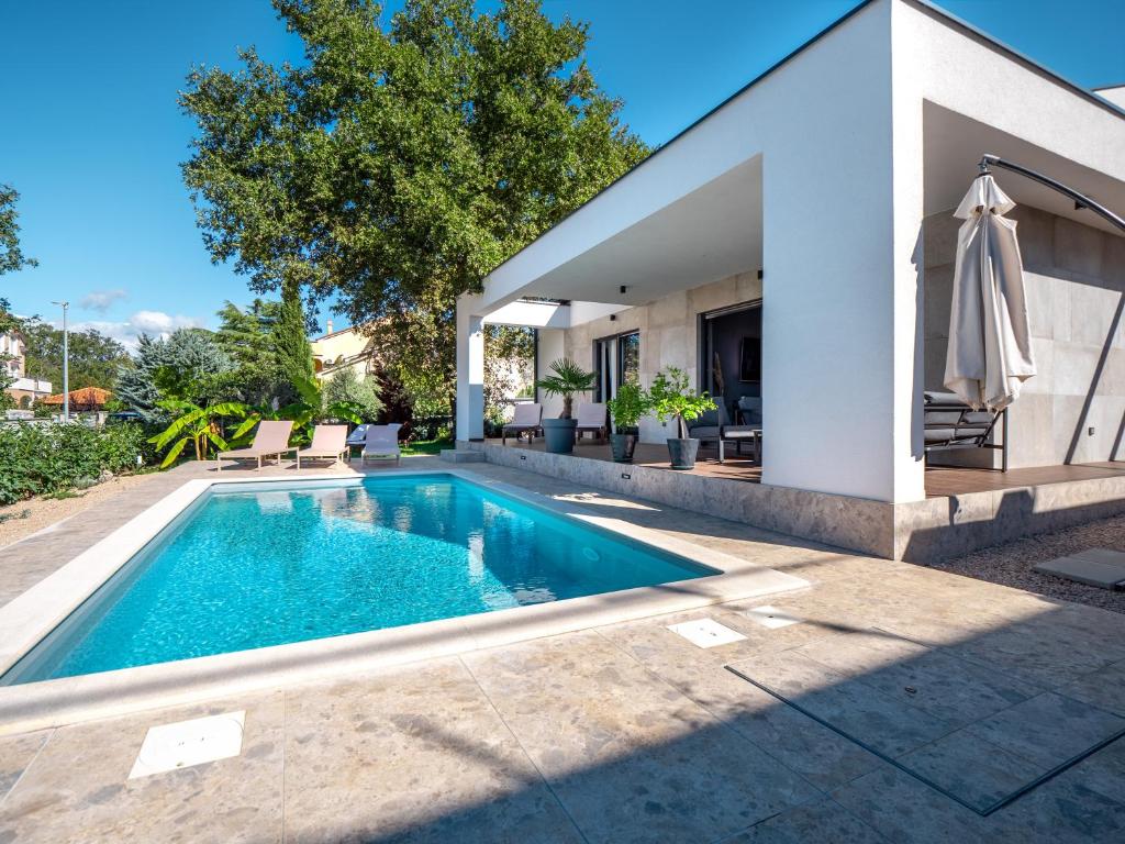 a swimming pool in the backyard of a house at Casa Dea in Malinska