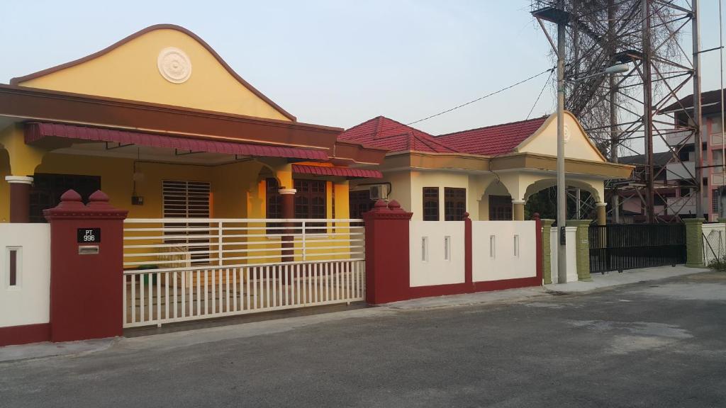 une maison avec une clôture devant elle dans l'établissement MJ Homestay Kota Bharu, à Kota Bharu