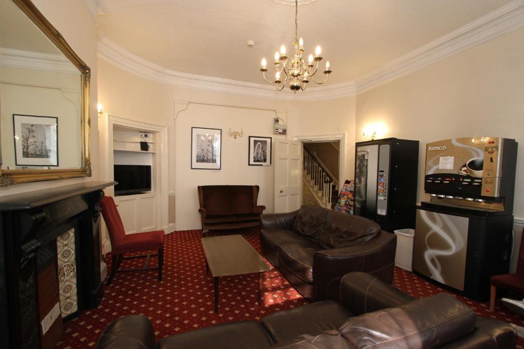 a living room with a couch and a fireplace at Ridgemount Hotel in London