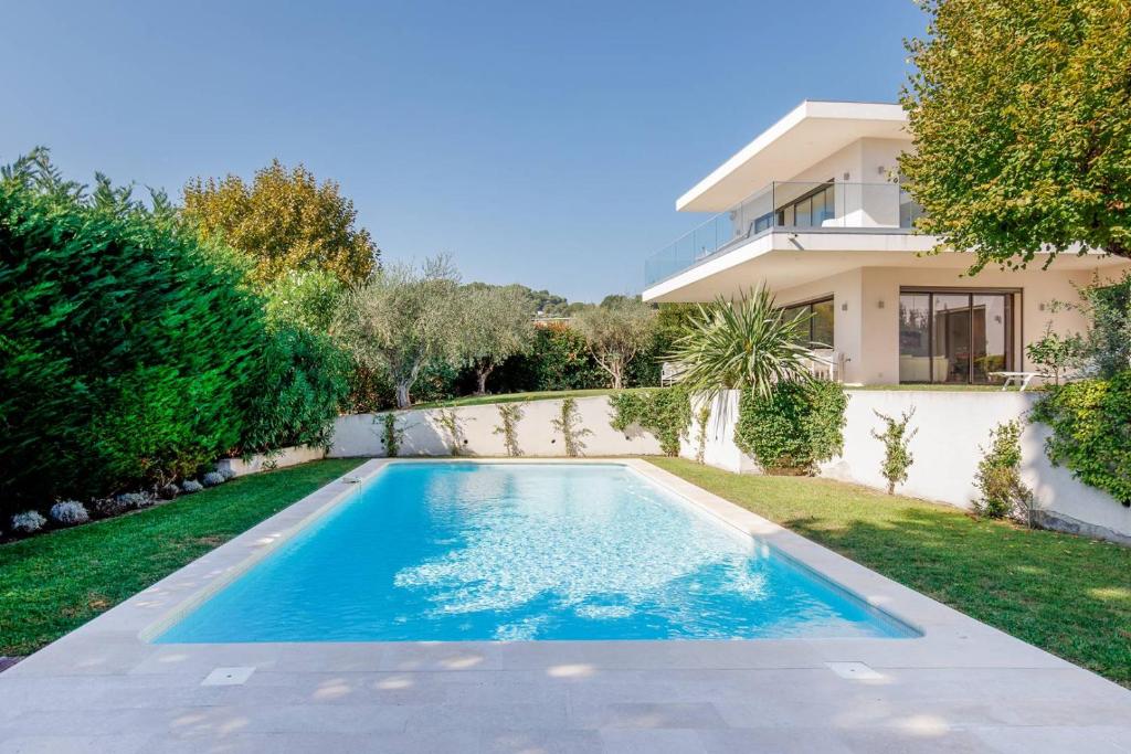 une piscine devant une maison dans l'établissement Splendide villa contemporaine pour vos vacances de rêve à Mougins, à Mougins