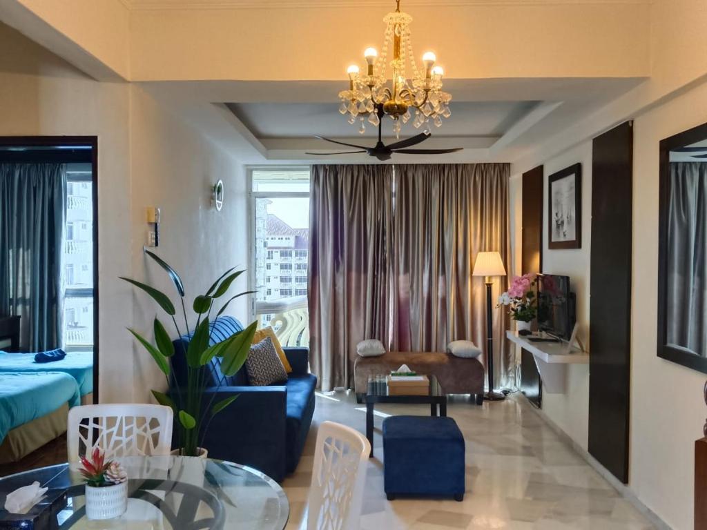 a living room with a couch and a chandelier at Jev Penthouse in Port Dickson
