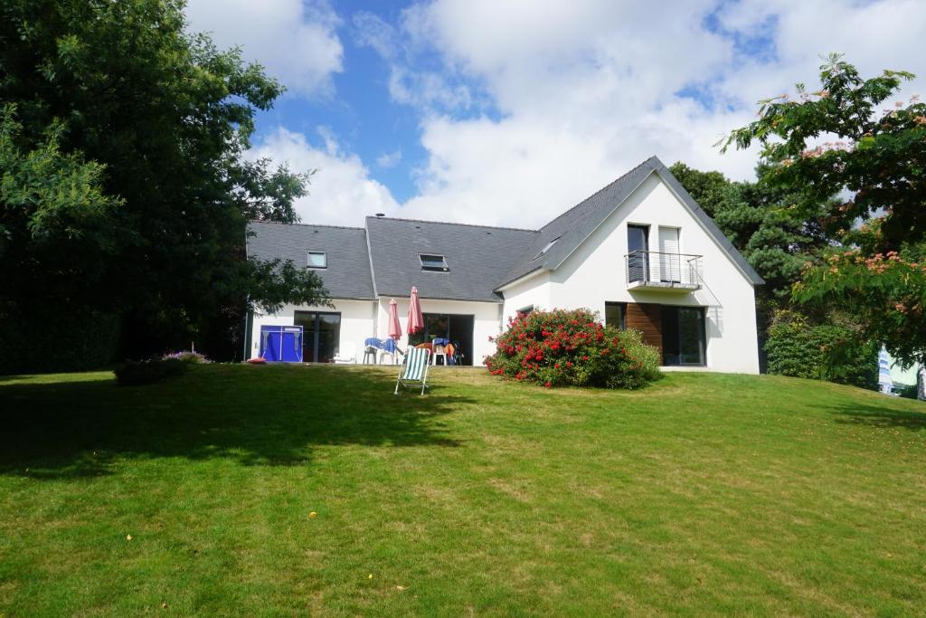 a white house with a lawn in front of it at Jolie maison de vacances avec une vue magnifique sur le jardin in Combrit