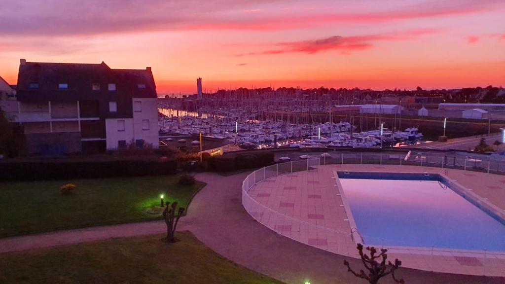 - un coucher de soleil sur un port avec une piscine dans l'établissement Soleil Crouesty, à Arzon