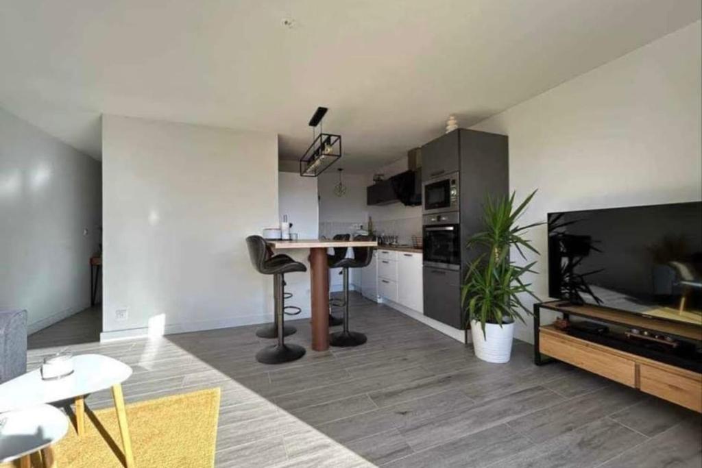 un salon avec une table et une cuisine dans l'établissement the cozy center, à Frontignan