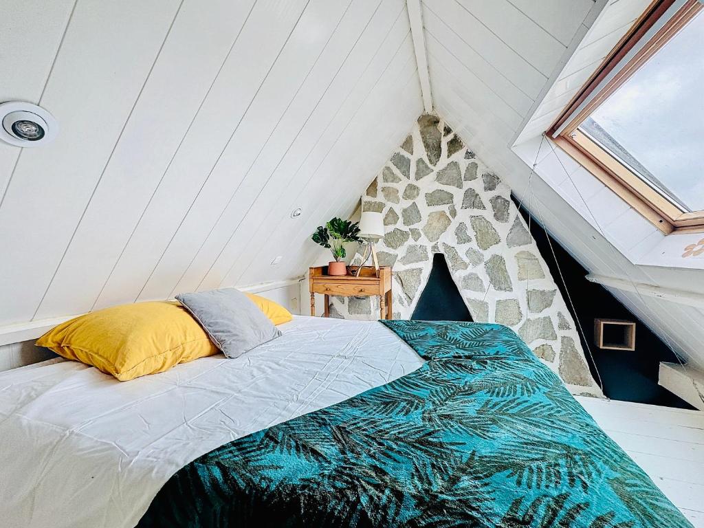 Suite Arthur - Détente & Charme في براي دون: غرفة نوم بها سرير في العلية