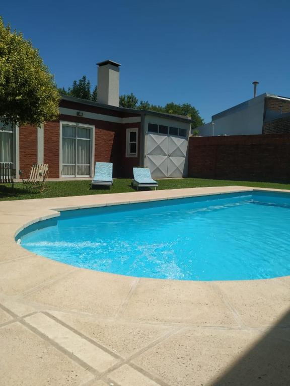 una grande piscina blu davanti a una casa di Mic-Bau a Villa Elisa