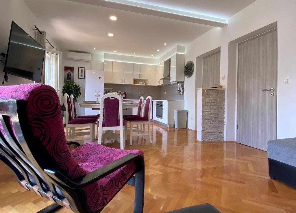 a living room with a kitchen and a dining room at Apartments Karla in Stanići