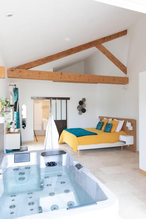 une chambre avec un lit et une baignoire dans une pièce dans l'établissement Mas des Tourterelles, à Jonquières