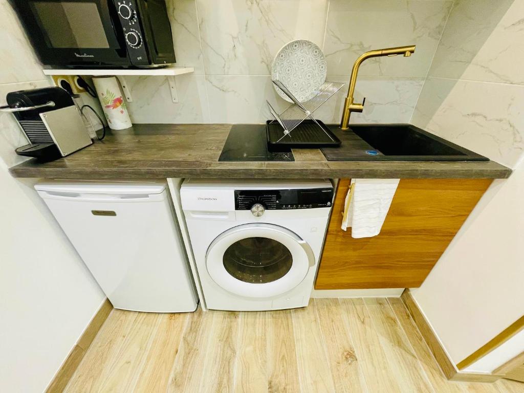 une cuisine avec une machine à laver et un évier dans l'établissement Studio Mozart Passy Paris, à Paris