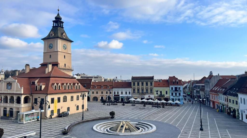 a city with a clock tower on a building at The Stag Ultracentral OldTown Apartment in Braşov