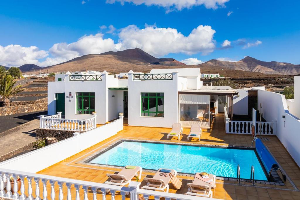 willa z basenem i górami w tle w obiekcie Villa Sol Y Mar w mieście Yaiza