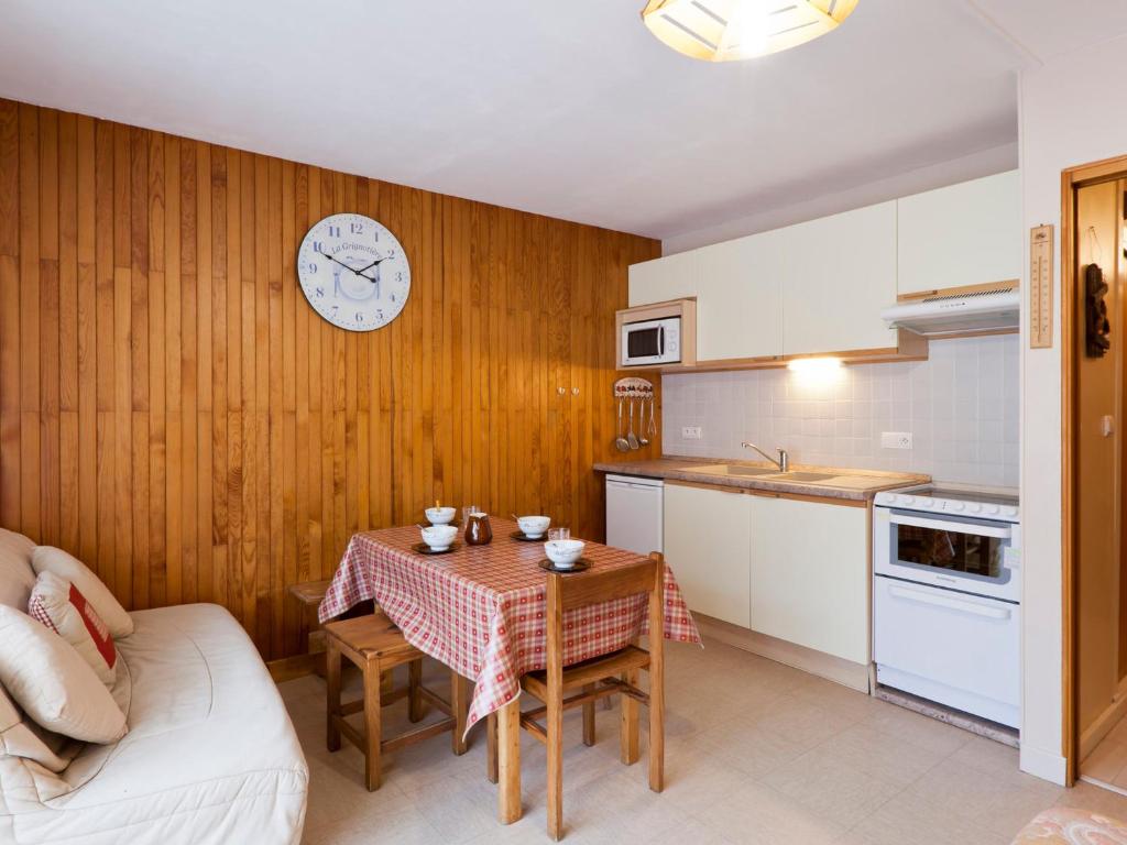 une cuisine avec une table et une horloge au mur dans l'établissement Studio 5 pers, centre Brides-les-Bains, balcon, proche thermes et télécabine - FR-1-512-19, à Brides-les-Bains