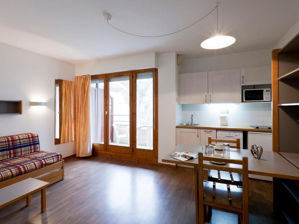 une cuisine et un salon avec un canapé et une table dans l'établissement Studio 2 pers, centre-ville, près des thermes, balcon, WiFi, télécabine à 200m, parking dispo - FR-1-512-97, à Brides-les-Bains