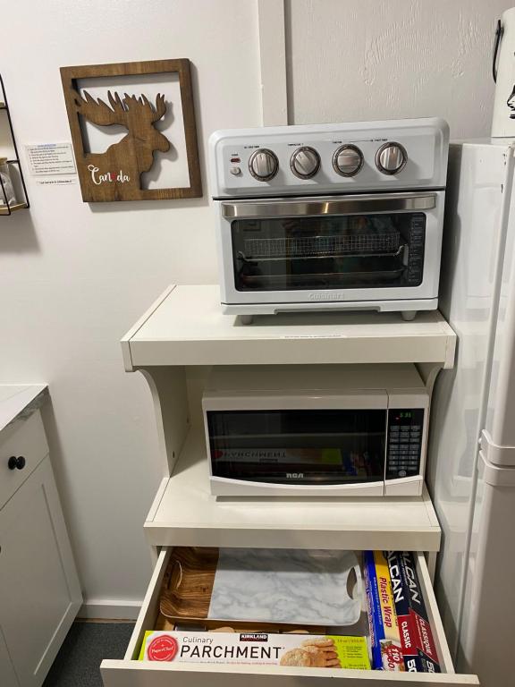 a microwave oven sitting on top of a white shelf at Our Place Up North BnB in Huntsville