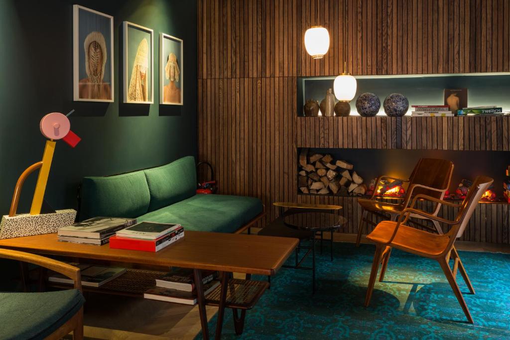 
a living room filled with furniture and a fire place at COQ Hotel Paris in Paris
