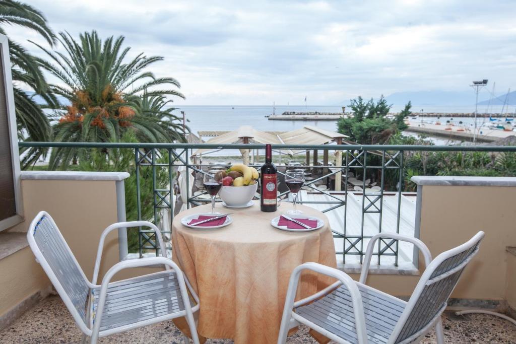einen Tisch und Stühle auf einem Balkon mit Blick auf den Strand in der Unterkunft Ignatia Hotel in Nafplio