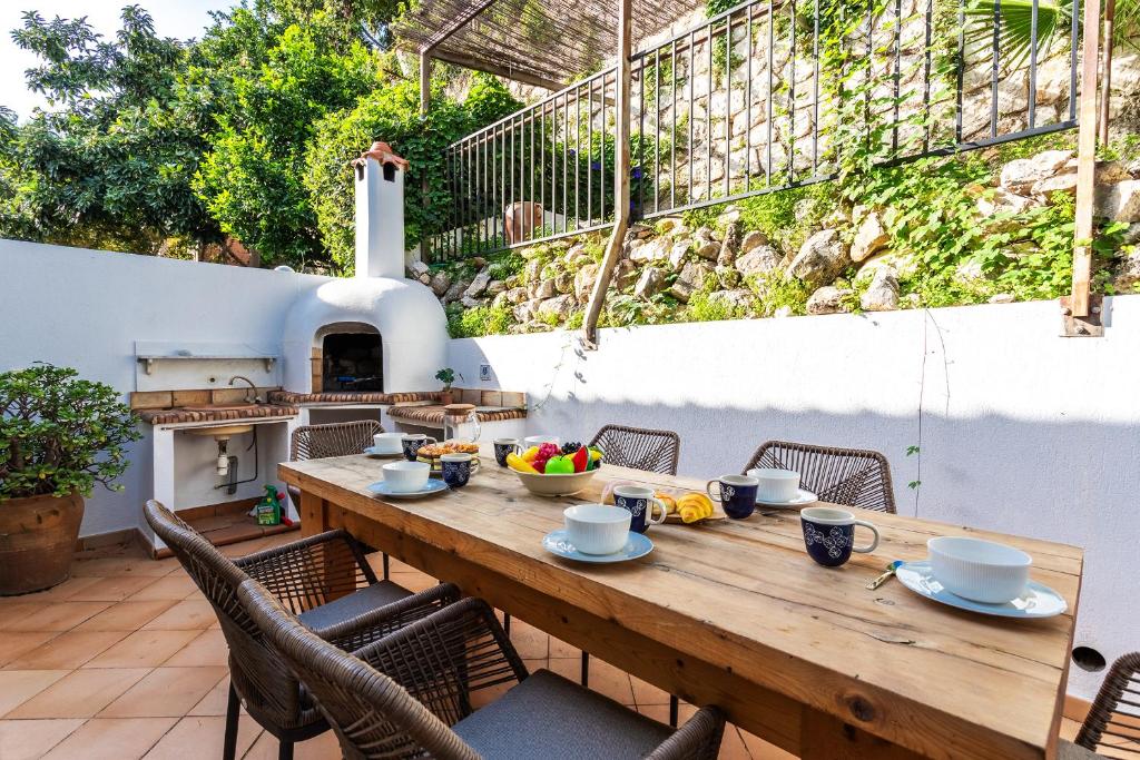 a wooden table and chairs on a patio with an outdoor oven at VILLA LUNA VI4339 By Riviera Holiday Homes in Èze