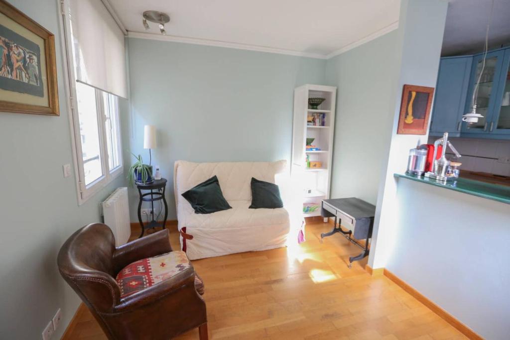 un salon avec un canapé et une chaise dans l'établissement Bright pied-à-terre Eiffel Tower 4 people, à Paris