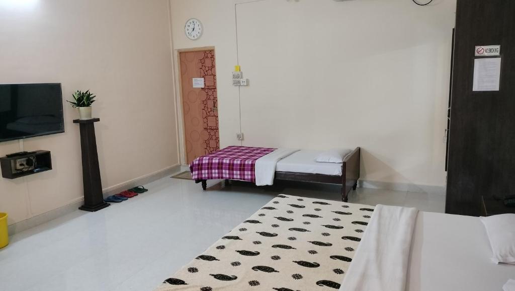 a room with a bed and a rug and a tv at Bononi in Jorhāt