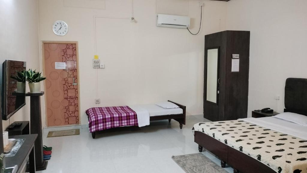 a hospital room with two beds and a mirror at Bononi in Jorhāt