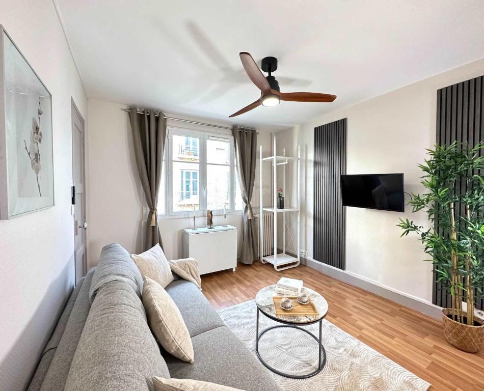 un salon avec un canapé et un ventilateur de plafond dans l'établissement Beautiful Studio near Parc des Expositions, à Paris