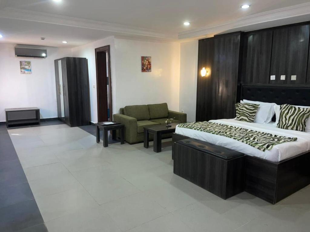 una camera d'albergo con un letto e un divano di SG - AA Hotel ad Abuja
