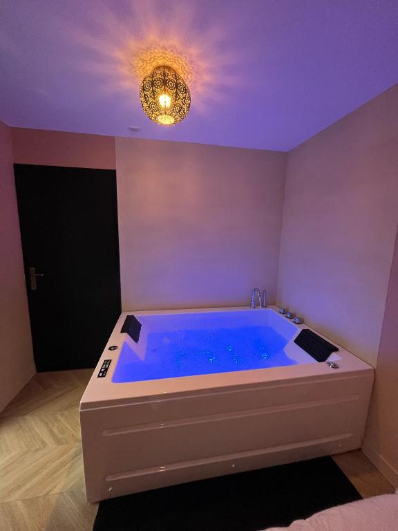 - une grande baignoire bleue dans une chambre avec plafond dans l'établissement Appartement Balnéothérapie, à Cenon