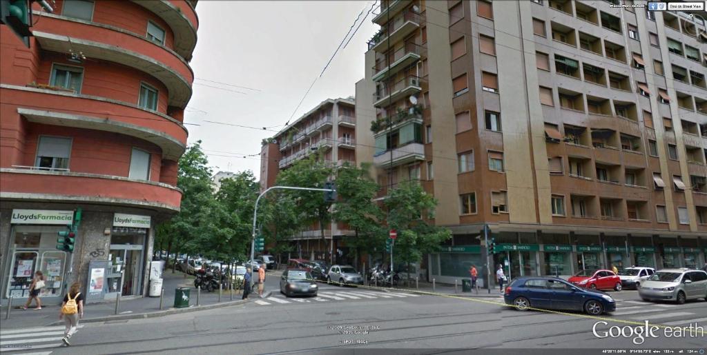 una concurrida calle de la ciudad con coches y edificios en Apartment Quattro en Milán