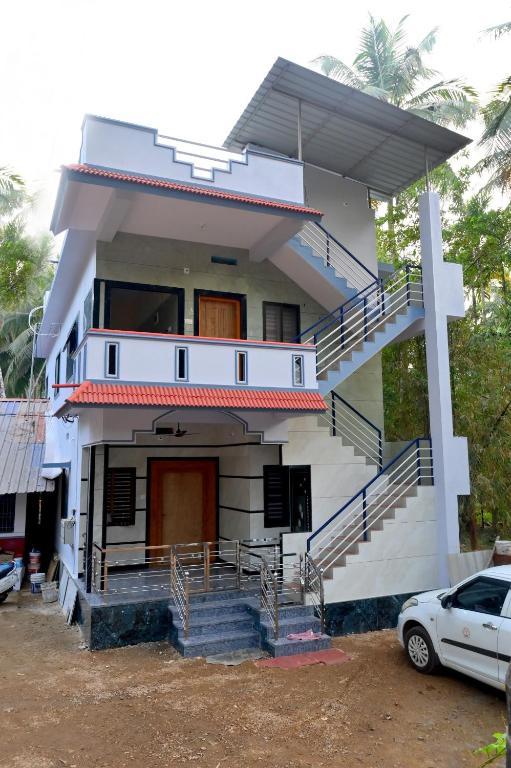 a house with a car parked in front of it at Louis Homestay in Māvalli