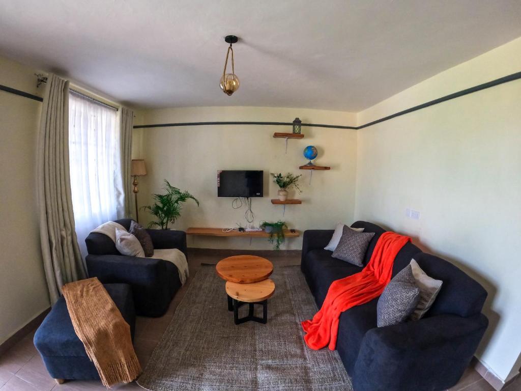 Una sala de estar con dos sofás y una mesa. en Savannah Suites Gilgil, en Gilgil